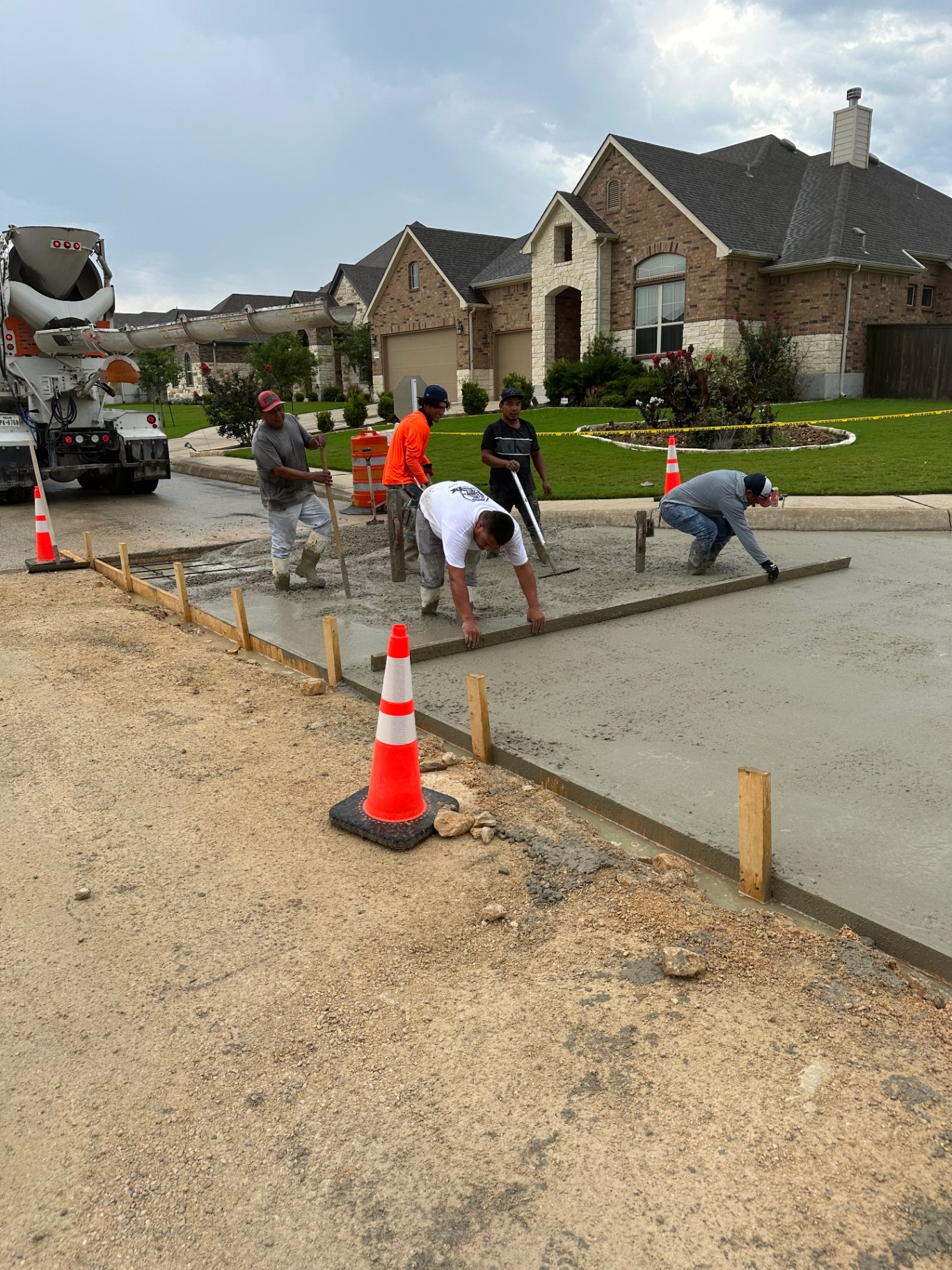 City Concrete Construction crew coordinating slab placement and edge finishing on an active residential road project