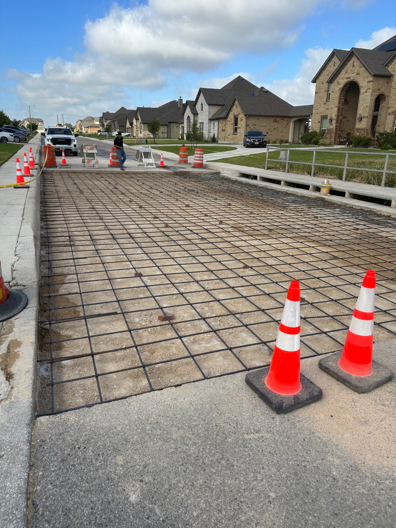 Prepared street section with rebar grid layout and traffic control before a concrete road pour
